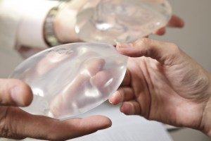 Doctor Shows Patient Breast Implant Options Closeup Hands