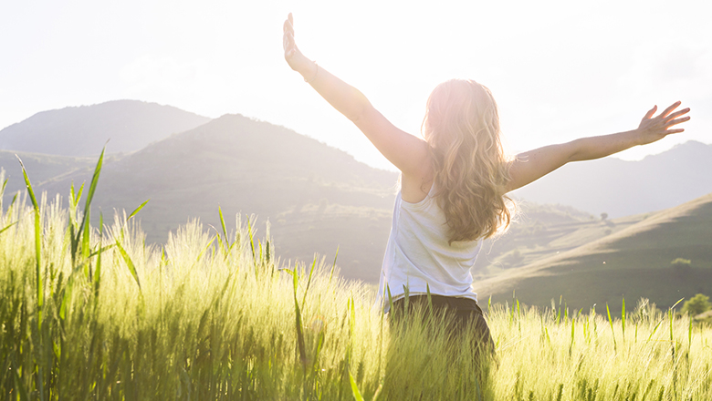 woman with arms outstretched in a field