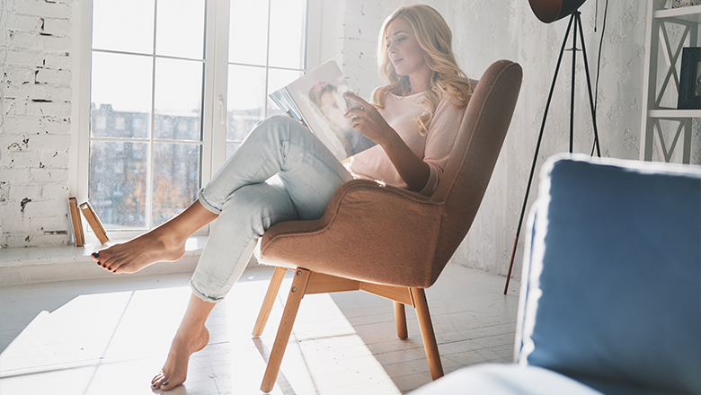 woman looking through celebrity magazine