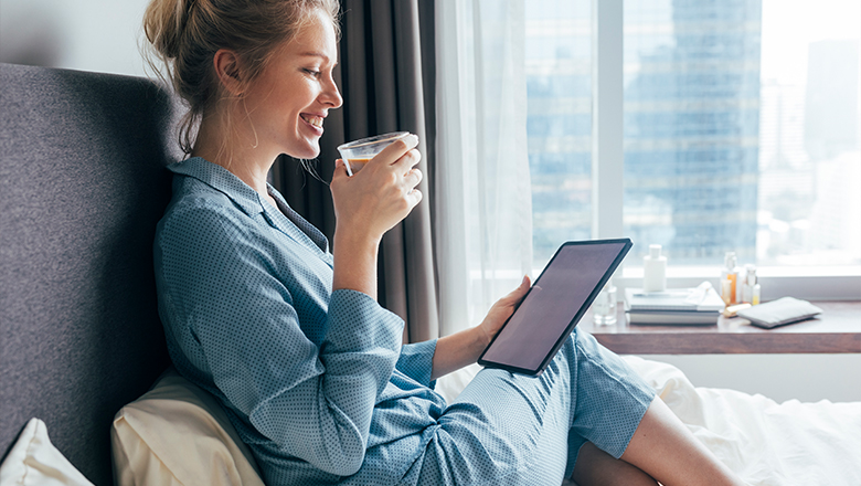 photo of a woman in sleepwear relaxing in bed at home